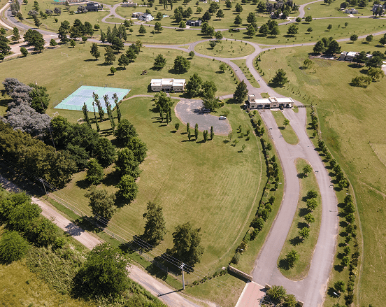Vista aérea de un parque verde con árboles y senderos.