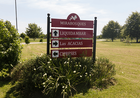 Señalización en el parque Mirabosques que muestra los senderos hacia Liquidambar, Las Acacias y Cereses.