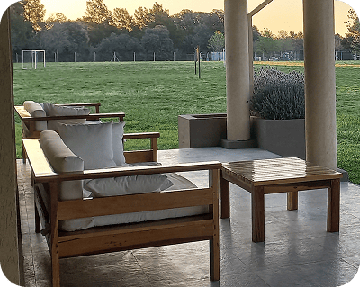 Imagen ilustrativa de un sillón de madera con un campo de fondo.