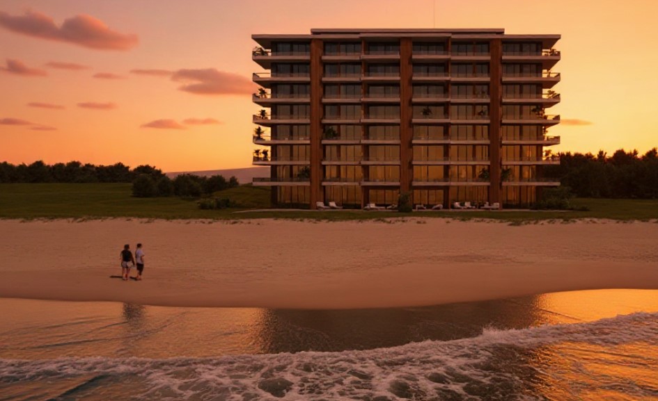 Render arquitectónico de un edificio moderno frente al mar al atardecer, con grandes ventanales, detalles en madera vertical y personas caminando en la playa.