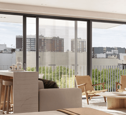 Living moderno con cocina integrada, entrepiso con baranda blanca y escalera, tonos madera y luz natural.