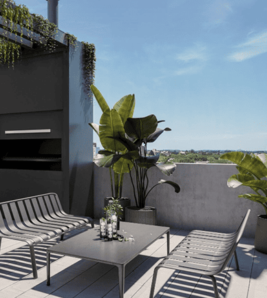 Terraza moderna con sillones metálicos, mesa baja y plantas grandes bajo cielo despejado y vista abierta