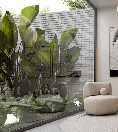 Interior luminoso con sillón moderno junto a ventanal con vista a jardín y muro de ladrillo blanco.