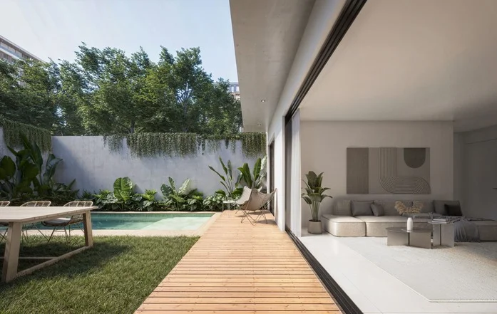 Patio moderno con deck de madera, piscina rectangular, vegetación frondosa y living integrado al interior.