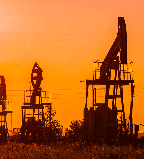 Bombas extractoras de petróleo en silueta durante un atardecer, representando la industria energética y la extracción de combustibles fósiles.